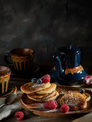 Homemade pancakes with raspberries and blueberries on a wooden rustic table