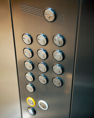 Elevator buttons with selected focus. Vertical closeup photo inside of reflective metal elevator