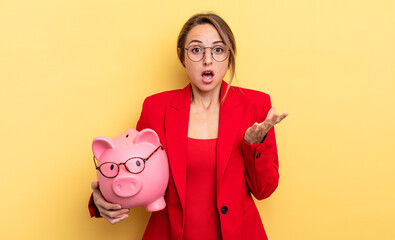 businesswoman amazed, shocked and astonished with an unbelievable surprise. piggy bank concept