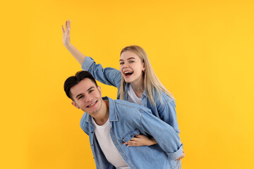 Cute and happy couple on yellow background