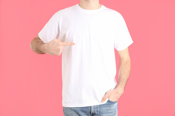 Man in blank white t-shirt on pink background