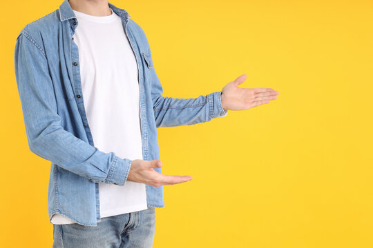 Man in blank t-shirt and in shirt on yellow background