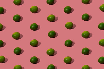 Organic green lime pattern on a pastel pink background. Hipster flat lay concept.