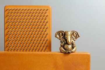 Bronze statue of Lord Ganesha, hindu God.. Brown Sadhu wooden boards with nails for yoga and...