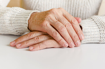 Hahds of an elderly woman on white background. Close up, copy space.