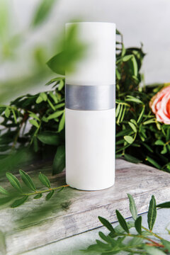 White cosmetics bottle with space for text with colors on the background. Container for care cosmetics on a wooden stand. Cosmetics and skin care