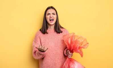 pretty woman looking desperate, frustrated and stressed. trash bag concept