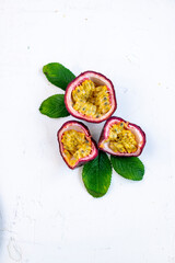 Fresh ripe passion fruits (maracuyas) on white background with water drops