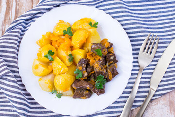 Roast beef liver with potatoes, onions and carrots. Delicious meat dish.