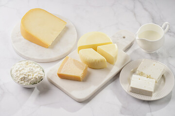 Various cheese types on marble and porcelain plates - ingredients for traditional georgian open pie khachapuri