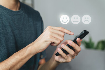 Man customer touching smartphone screen on the happy Smile face icon to give satisfaction. Review, Service rating, satisfaction, Customer service experience, and satisfaction survey concept.