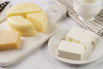 Various cheese types on marble and porcelain plates - ingredients for traditional georgian open pie khachapuri