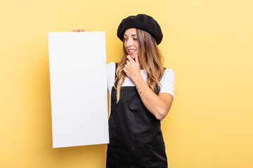 woman artist smiling with a happy, confident expression with hand on chin empty canvas concept