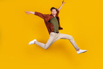 Fototapeta na wymiar Full body photo of young excited guy good mood jump up run travel trip isolated over yellow color background