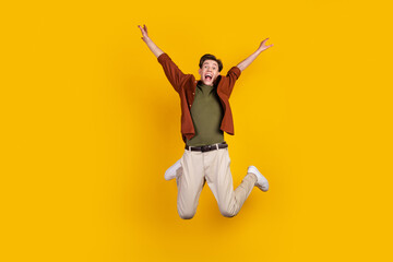 Full length photo of young man astonished jump up scream wear casual clothes isolated over yellow color background