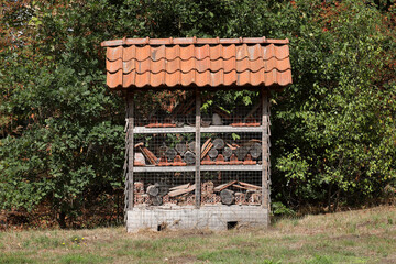 An insect hotel builld at the edge of a forest. Insect hotels are build to house all kinds of...
