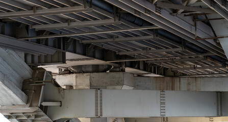 Framework under bridge. Metalwork. From the bottom of large bridge. Grey metal, modern design. Load-bearing metal structures of railway overpass