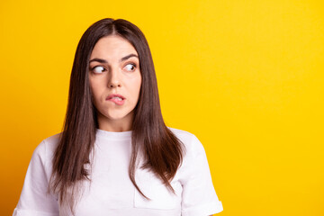 Fototapeta premium Photo of young pretty lady bite lips wondered look empty space scared worried look empty space isolated over yellow color background