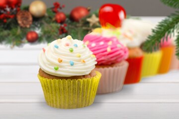 Christmas muffins with creamy frosting and green fir tree branches. Vanilla cupcakes, winter and new year dessert.
