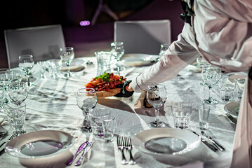 woman hands of a waiter prepare food for a buffet table in a restaurant