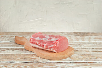 Raw steak on a wooden board. Meat on a white wooden background. Food on an old shabby table.