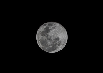 Close up photography of the moon with a telephoto lens, very sharp and detailed where you can see crates in a full moon phase.