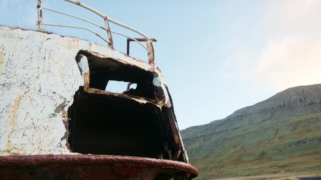 Cracked hull of a shipwreck and the hilly background of Iceland