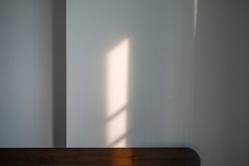 The sunlight shines into the room on the wall of the room.