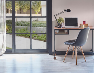 Modern rom with working table and armchair style, parquet floor, frame lamp decor, curtain, garden view house interior.