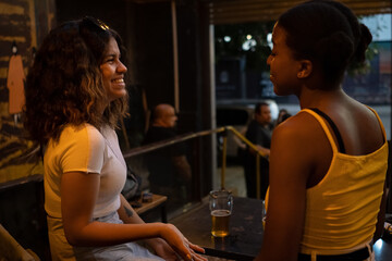 Women sitting at table in pub talking and laugh.