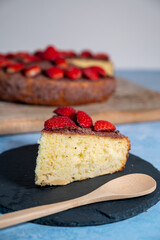 vertical shot of a piece of homemade cake with fresh strawberries