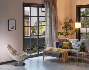 Room interior sofa and working table style, metal lamp, vase of plant, garden view, middle coffee table, blanket, parquet floor, home design.