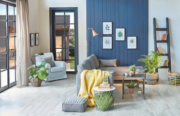 Modern grey sofa in the blue room with leaf frame, blanket , middle table, lamp, armchair, garden...