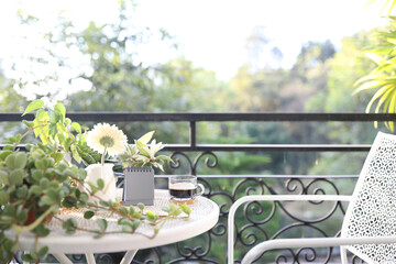 mini calendar and glass of coffee with flower on metal table at balcony