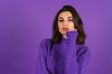 Young woman in a purple soft cozy sweater on the background of cute smiling cheerfully, in high spirits, confident smile, bright makeup with lipstick