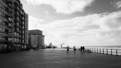 Fototapeta premium People walking on the Ostende boardwalk, black and white