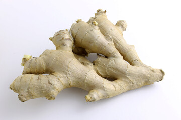 Fresh ginger root on a white plate close-up. A piece of ginger root top view.