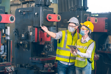 white and yellow helmet engineer explain about machine in industial factory how in work and how to maintain