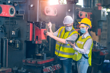 Co-working Engineer white helmet and yellow helmet  in industial factory working together fix the machine by maintenance cycle