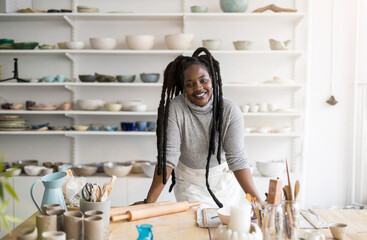 Confident female pottery artist in her art studio

