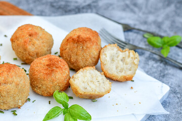 Italian arancini Cacio e pepe. Home-made rice balls with mozzarella cheese, parsley, lemon, and parmesan cheese.