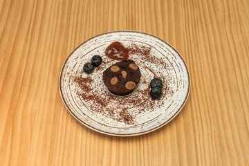 A brownie, typical of the United States. It is named for its dark brown color. It is sometimes covered in a thick chocolate syrup and may contain chunks of nuts, chocolate, caramel, peanut butter.