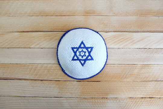 Jewish kippah hat with star of David on wooden background with a copy space