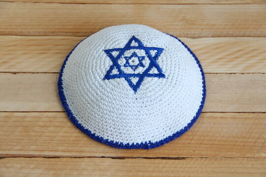 Jewish kippah hat with star of David on wooden background