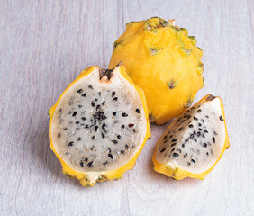 Pitahaya, dragon fruit whole and cut on a light wooden background