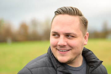 Young man looking aside wuth a quiet smile