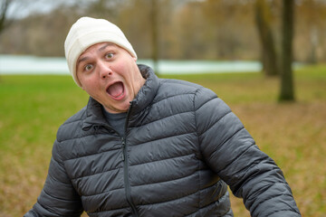 Playful young man in a beanie sticking out his tongue