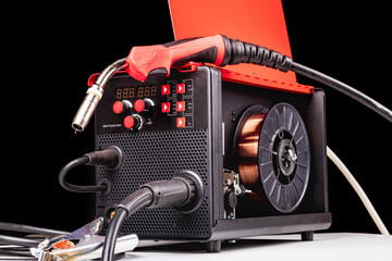 dark background. it has an assembly for welding metal products. red color. close-up.