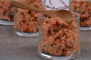Tartare de saumon dans une verrine avec une cuillère en bois en gros plan