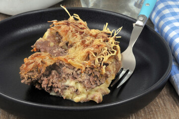 Portion de hachis parmentier dans une assiette avec une fourchette en gros plan
